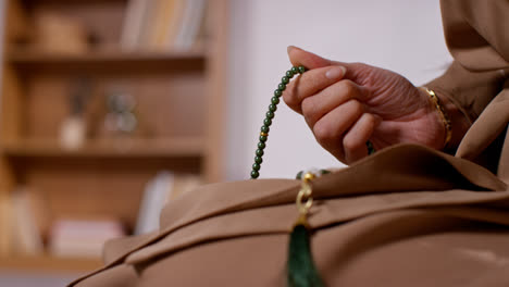 Close-Up-Of-Muslim-Woman-With-Prayer-Beads-At-Home-Praying